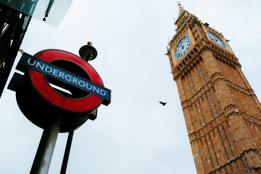 Iconic view of London's Big Ben and Underground sign on an overcast day, capturing the essence of the city.
